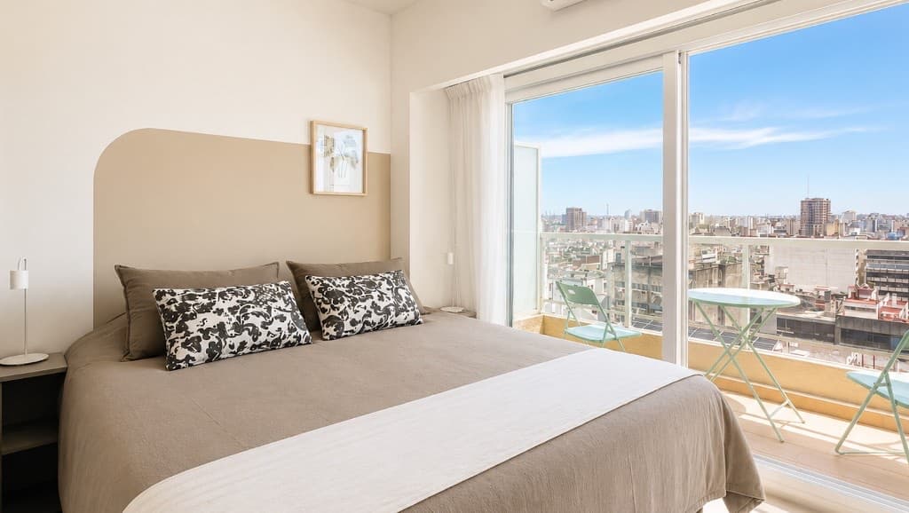 Dormitorio del Apto. 1429 en el piso 14, con cama doble y vista panorámica al centro porteño