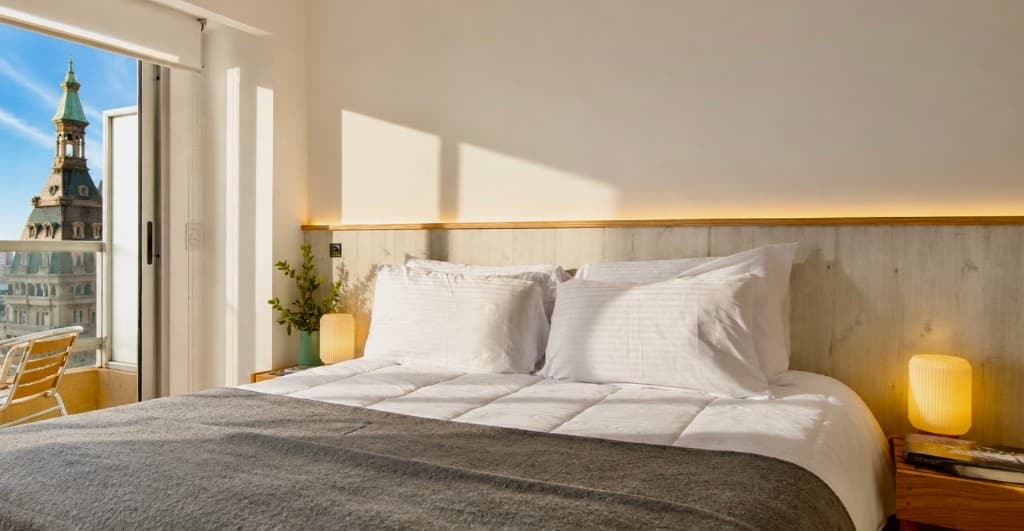 Dormitorio del Apto. 1430 en el piso 14, con cama doble y vista panorámica al centro porteño