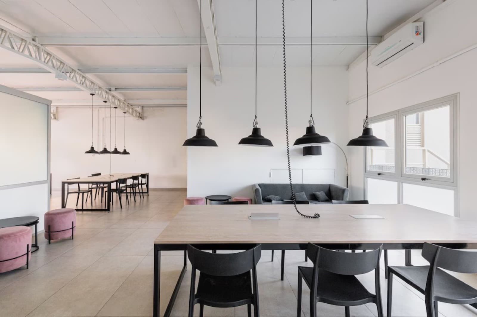 Sala de coworking con mesa comunitaria y ventanal
