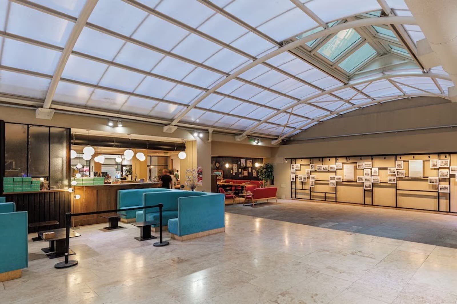 Hall de planta baja con claraboya de vidrio y boxes turquesas