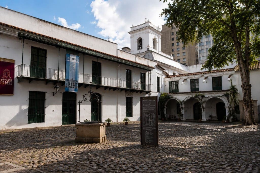 Patio empedrado y galerías coloniales blancas de la Manzana de las Luces