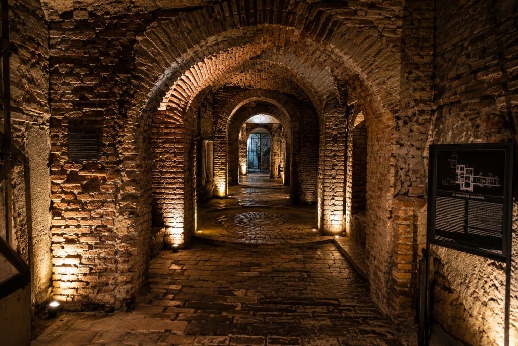 Arcos de ladrillo iluminados en los túneles subterráneos de El Zanjón de Granados